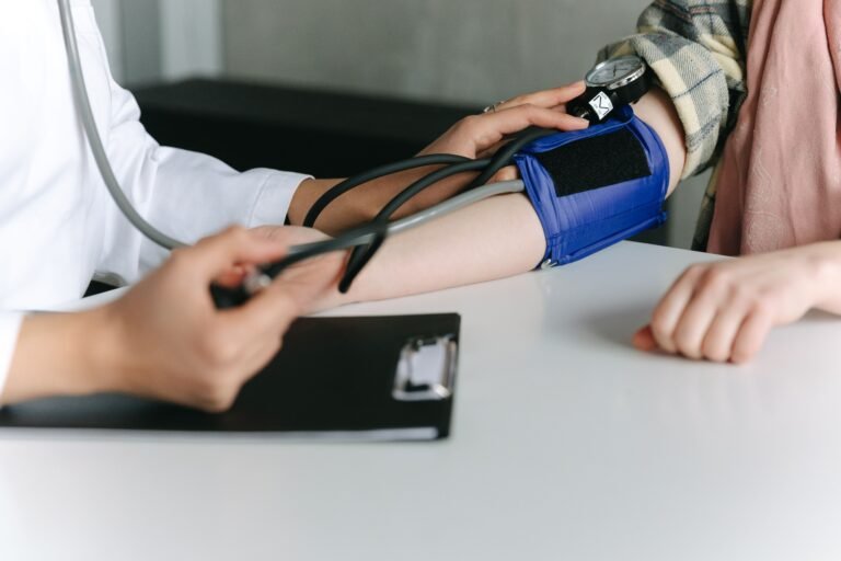 Healthcare worker checking an employee's blood pressure during a corporate health screening session