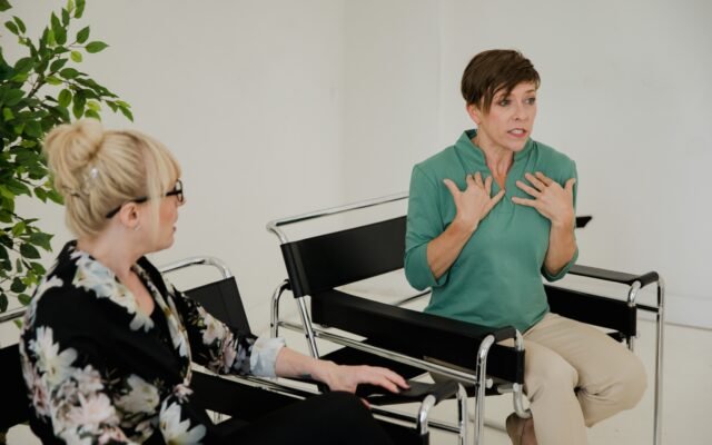 Two colleagues having a supportive conversation about workplace mental wellbeing