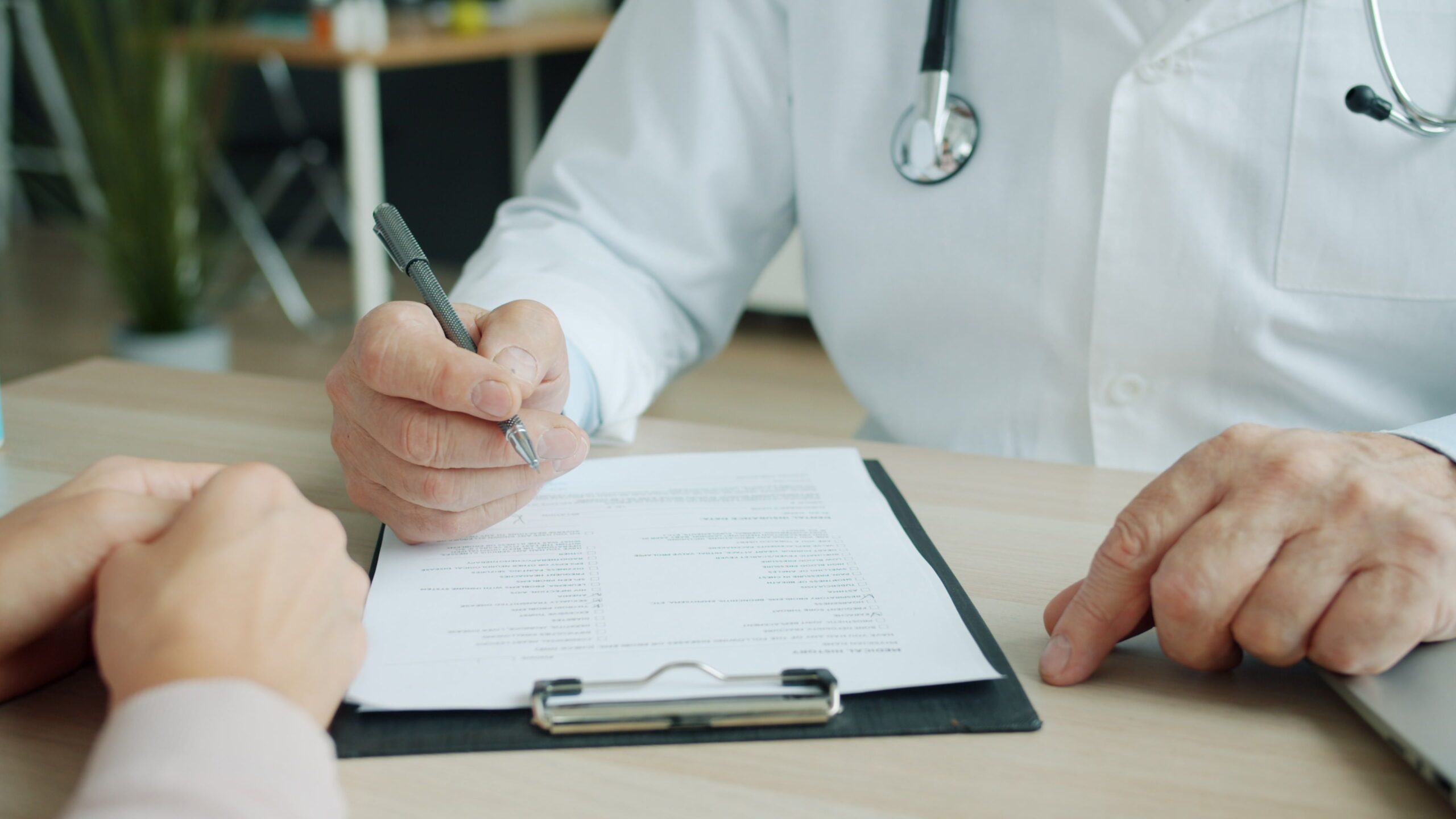 Doctor and patient reviewing a medical report together before it is shared with an insurer