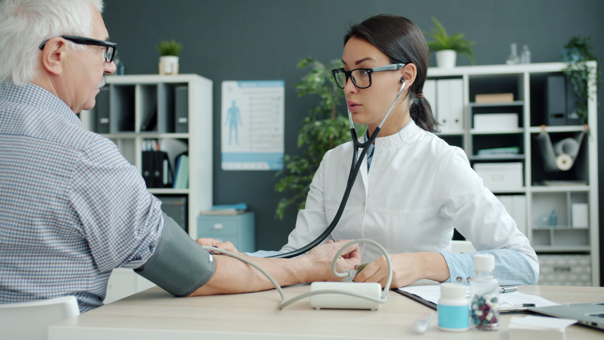 Healthcare professional checking a senior patient's blood pressure for chronic care under the MediSave Chronic and Preventive Care scheme