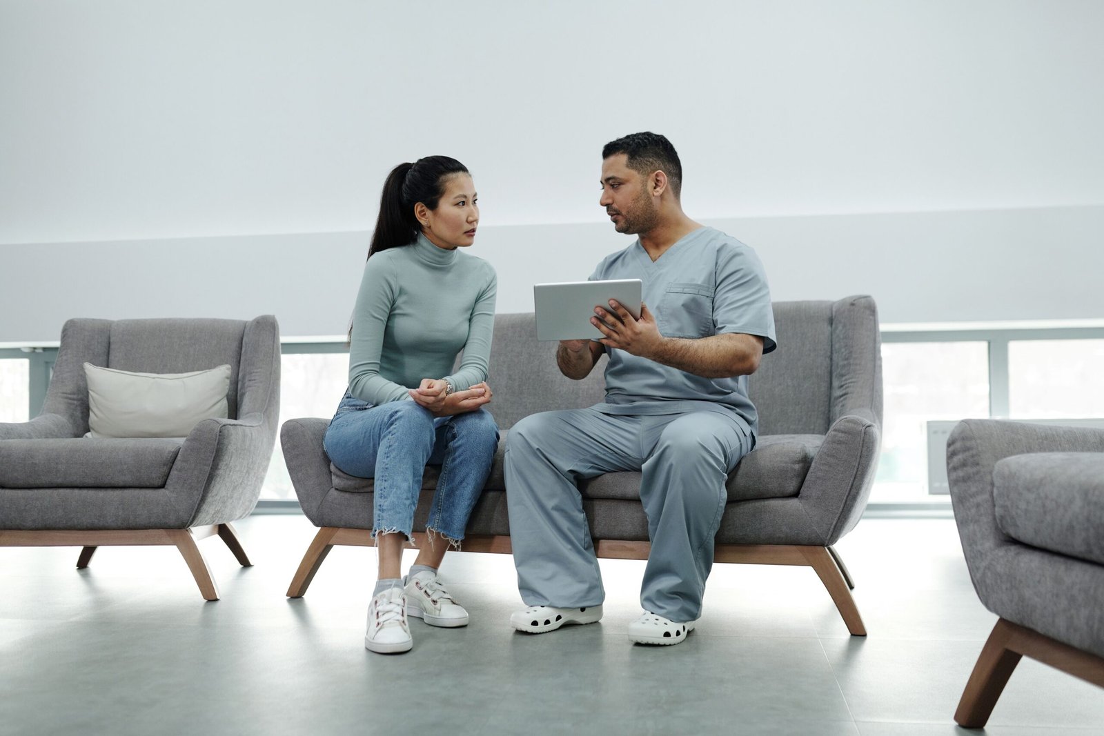Doctor Explaining Risk Results to a Patient GP explaining health risk results to a patient on a tablet at a Healthier SG clinic